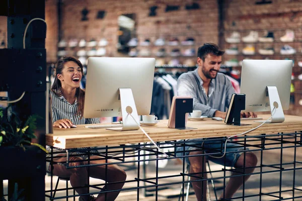 職場で楽しい時間を過ごし コンピュータや笑いに取り組んでいる店の若い労働者 チームワーク インターネットカフェのコンセプト — ストック写真