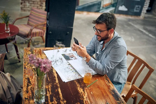 Kafede Güneş Gözlüklü Yakışıklı Genç Adam Akıllı Telefon Tutuyor Telefonda — Stok fotoğraf