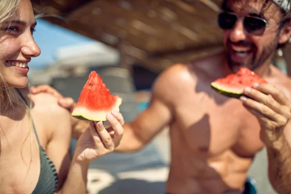 快乐的夫妻在海滩度假时一起放松一下 一起吃西瓜 — 图库照片