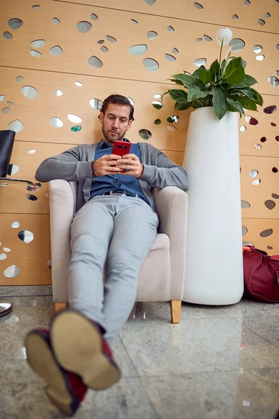 Ung Affärsman Sitter Hotellets Lobby Avslappnad Atmosfär Och Använder Smartphone — Stockfoto