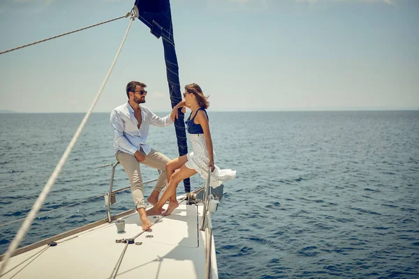 一对年轻夫妇在游艇的船头上聊天 一边欣赏风景 一边在美丽的阳光明媚的海面上搭便车 人际关系 — 图库照片