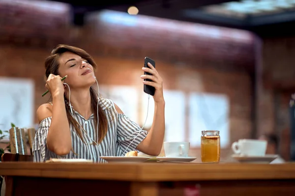 Young Woman Enjoying Music Cafe Holding Pen Feeling Inspired Lifestyle — Stock Photo, Image