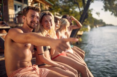 Genç çift rıhtımda oturuyor ve birlikte eğleniyorlar.