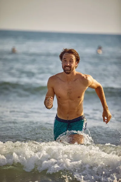 Ευτυχισμένος Άνθρωπος Τρέχει Στο Νερό Στην Παραλία — Φωτογραφία Αρχείου
