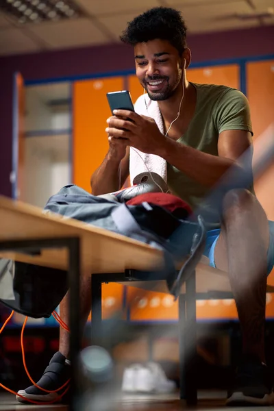 Snygg Ung Man Med Hörlurar Leende Hålla Smartphone Skriva Förberedelser — Stockfoto