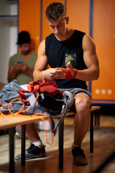 年轻英俊的男子在更衣室 准备锻炼 捆绑保护带他的双手拳击 积极的生活方式 武术概念 — 图库照片