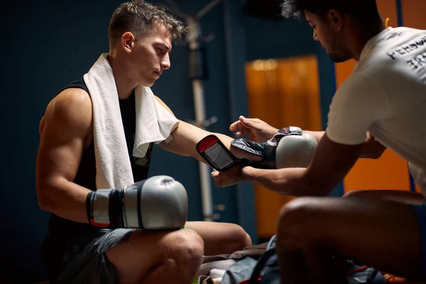 ボクシングワークアウトの準備をしている若いボクシングプレーヤー コーチは彼がボクシングの手袋を置くのを助ける スポーツ ライフスタイル 武道の概念 — ストック写真
