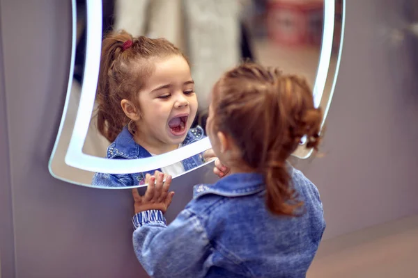 可爱的小女孩 她在用镜子里的倒影玩耍 — 图库照片