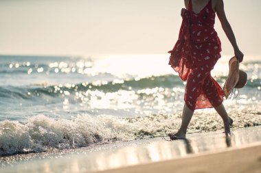 Genç bir kadın, güzel bir yaz gününde sahilde yalın ayak yürümekten hoşlanır. Yaz, sahil, deniz, tatil