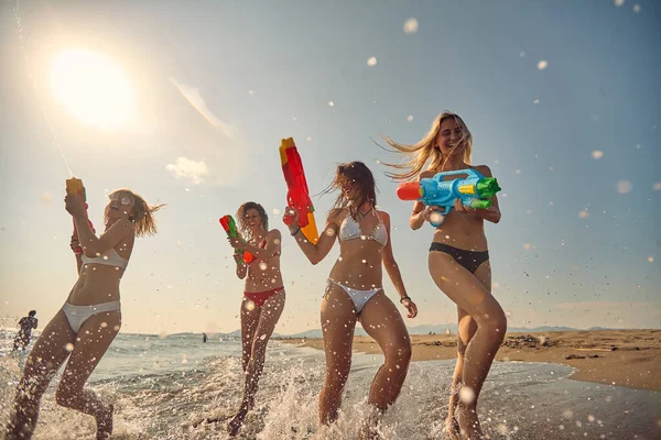 Young Beautiful Women Water Guns Running Shore Summertime Vacation Togetherness — Stock Photo, Image