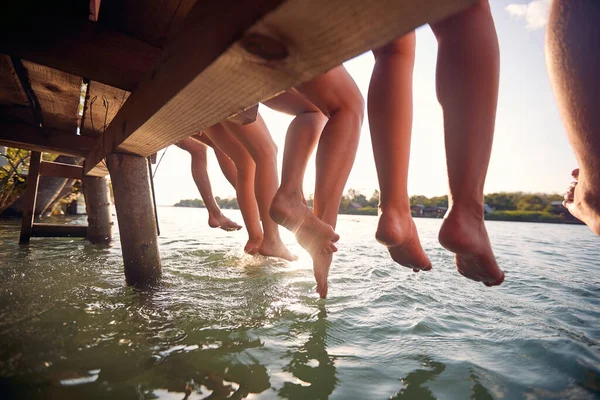 Genç Arkadaşlar Rıhtımda Oturuyor Tatilde Birlikte Eğleniyorlar Suda Sallanan Bacaklar — Stok fotoğraf