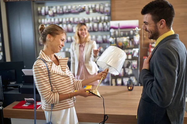 購入するランプを選択する若い男と女 彼女は彼女の夫に好きランプを示す女性 ショッピング ライフスタイルの概念 — ストック写真