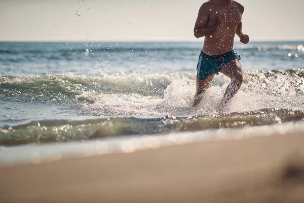 筋肉のハンサムな男は水の中を走る輝く水のドロップ — ストック写真
