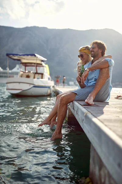 一对年轻夫妇正在海滨一个阳光明媚的日子 在码头上休息 — 图库照片