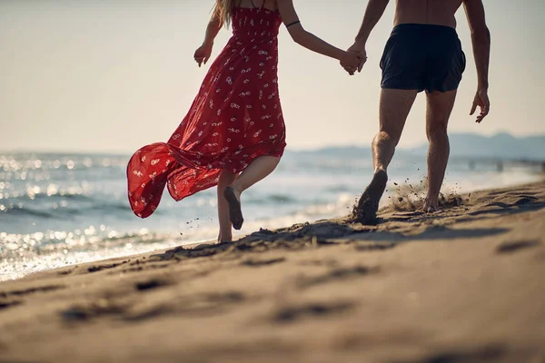 在一个美丽的夏日 一对年轻夫妇在海滩上散步 — 图库照片