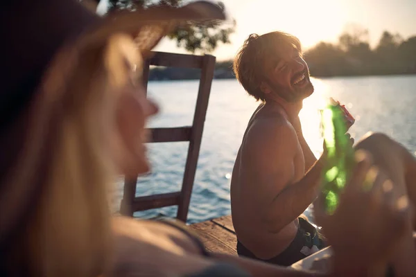 夏の日没の間に水でドックでスイカを食べる若い幸せな人々 — ストック写真
