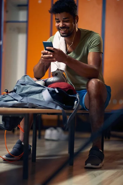 Yakışıklı Atletik Adam Soyunma Odasında Oturuyor Telefona Bakıyor Antrenmana Hazırlanıyor — Stok fotoğraf