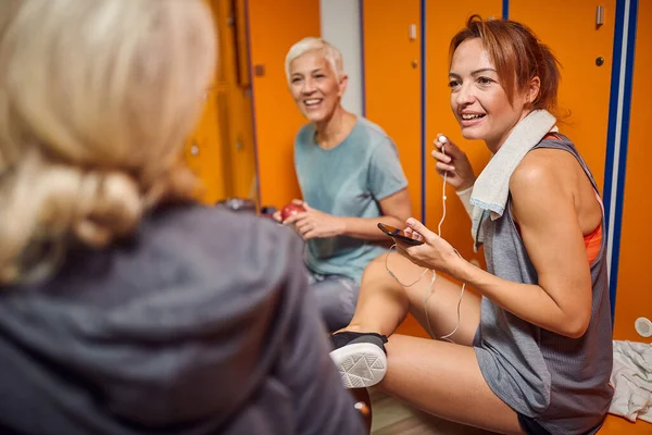 一群女人在体育馆更衣室里训练前 进行了一次谈话 与年轻培训师交谈的老年妇女 — 图库照片