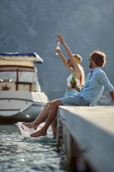 Young Couple Sitting Dock Seaside Enjoying Drink Beautiful Sunny Day — Stock Photo, Image