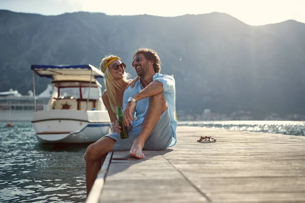 在海滨一个阳光明媚的日子 一对年轻夫妇坐在船坞边玩得很开心 — 图库照片