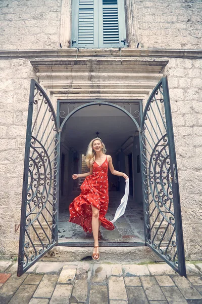 Fröhliche Blondine Springt Rotem Schwülem Kleid Und Fühlt Sich Glücklich — Stockfoto