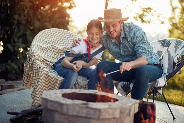 父と娘の関係と愛 彼らは一緒に座って しっかりと受け入れられ 激しい火の横に座って マシュマロを焙煎する楽しい活動に従事しています — ストック写真