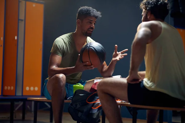 在更衣室里 一个年轻而健美的篮球男子和他的朋友在一起休息 向他的朋友解释一些事情 生活方式概念 — 图库照片