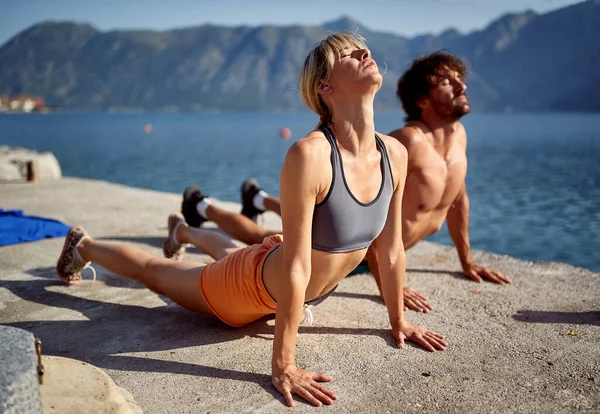 Pasangan Muda Tampan Melakukan Yoga Dermaga Pada Hari Yang Cerah — Stok Foto