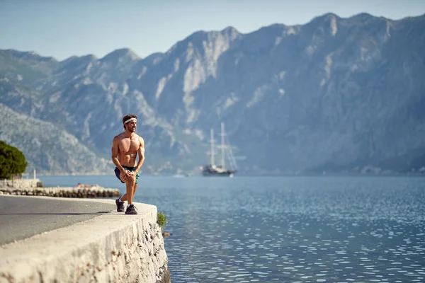 美しい湖の近くで若い筋肉の男の演習 — ストック写真