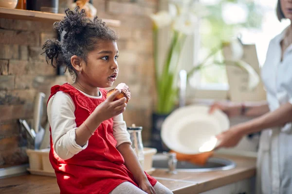 Menina Criança Senta Cozinha Deliciando Com Muffin Dar Água Boca — Fotografia de Stock