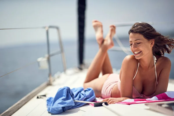 若い陽気なセクシーなモデルはリラックスしていて ヨットで美しい晴れた日に日光浴をしています — ストック写真
