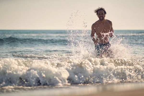 美しい夏の日にビーチで波で遊んでいる若い男 ビーチ — ストック写真