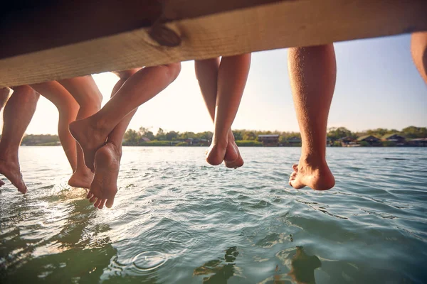 Přátelé Jezera Sedící Dřevěném Molu Nohama Visícíma Vodě Letních Prázdninách — Stock fotografie