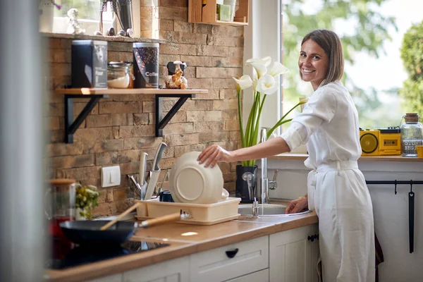 Joyful Young Woman Washing Dishes Modern Kitchen Putting Plate Away — Stock Photo, Image