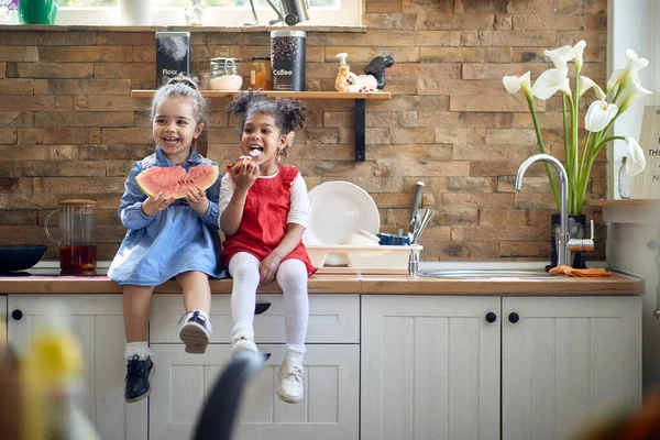 Dwie Słodkie Dziewczynki Siedzące Blat Kithcne Zachowując Się Głupio Ciesząc — Zdjęcie stockowe