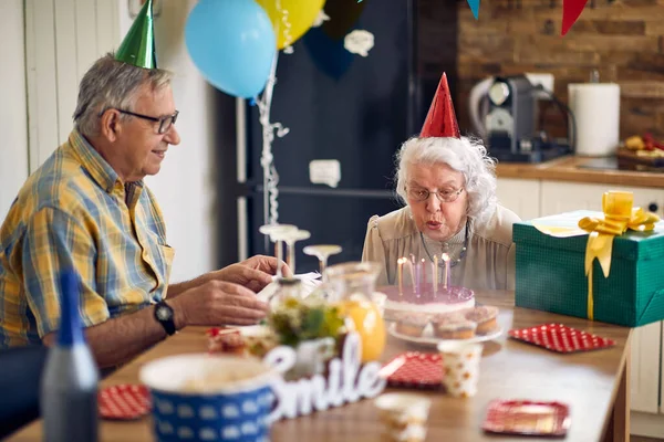 Gelukkige Oudere Vrouw Die Kaarsen Blaast Haar Verjaardagstaart Zittend Aan — Stockfoto