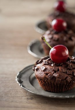 Taze vişneli ve çikolatalı kekler tabakta.