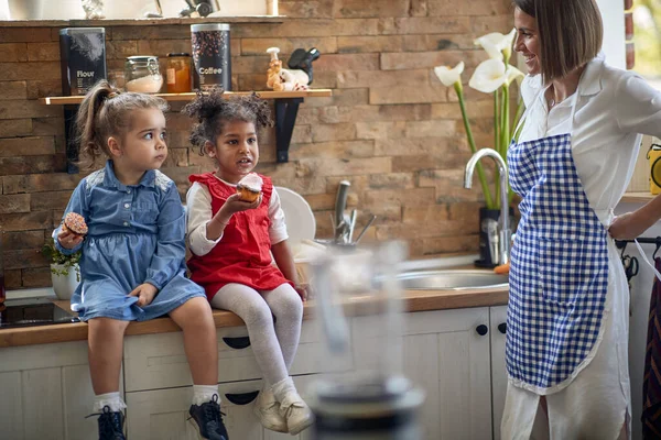 Genç Bir Kadın Anne Kızlarına Bakıyor Kek Yiyor Mutfak Tezgahında — Stok fotoğraf