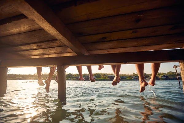 Amigos Juntos Sentados Doca Baía Desfrutando Pôr Sol — Fotografia de Stock