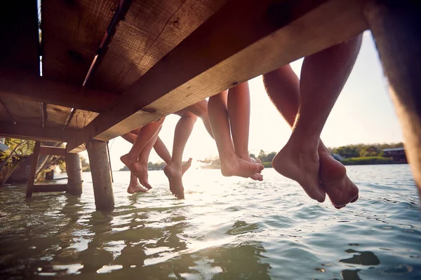 Mladí Přátelé Sedí Molu Užívají Společně Dovolené Visící Nohy Vodě — Stock fotografie