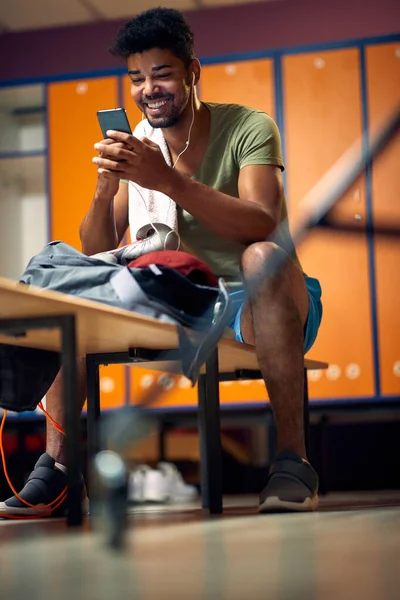Bello Giovane Atletico Guardando Gioioso Smartphone Digitando Messaggio Prendendo Una — Foto Stock