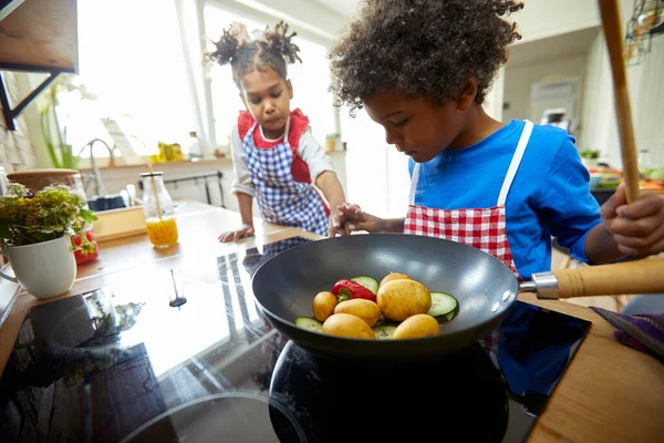 蹒跚学步的男孩和一个女孩假装是厨房里的小厨师 沉浸在充满想像力的游戏中 — 图库照片
