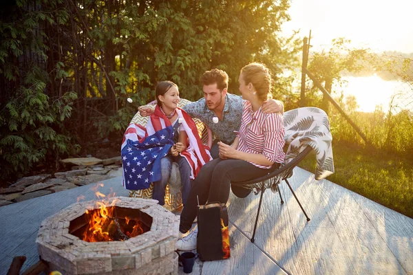 父母和女儿一起围坐在篝火边 分享着烤棉花糖的快乐 — 图库照片