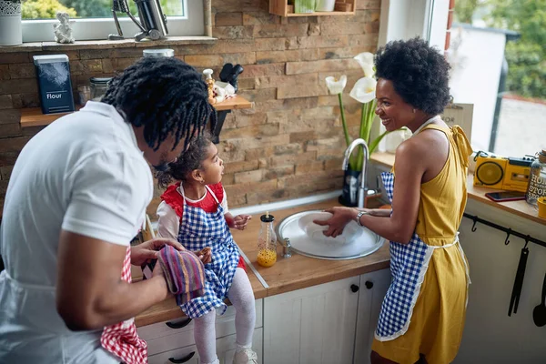 Οικογενειακή Αρμονία Μητέρα Πλένει Προσεκτικά Πιάτα Στην Κουζίνα Ενώ Πατέρας — Φωτογραφία Αρχείου