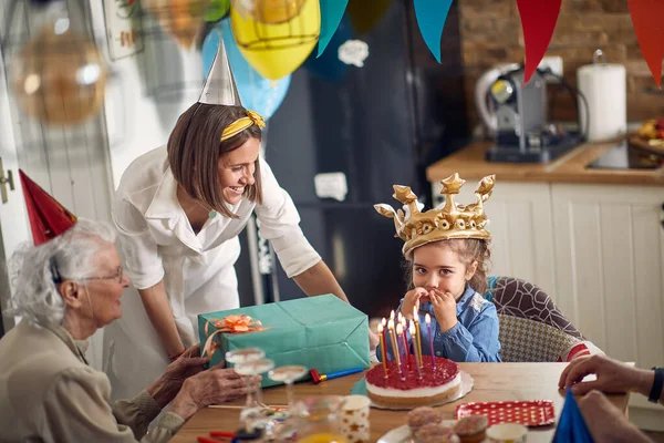 Happy Little Girl Making Wish Blowing Candles Cake Sitting Kitchen — Stock Photo, Image