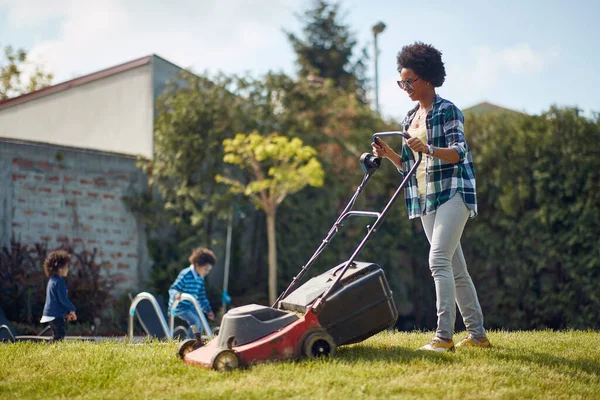 Responsibilities Mother Tends Lawn While Her Two Children Joyfully Engage — Stock Photo, Image