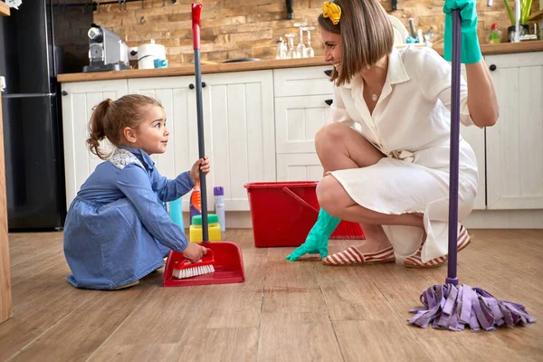 Cute Little Girl Helping Her Mother Cleaning Kitchen Sweeping Floor — Stock Photo, Image