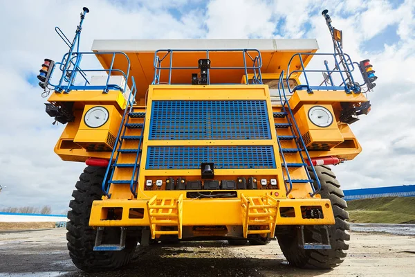 A large dump truck. Yellow dump truck controlled by a robot on the work site. Mining equipment for transporting coal with open-pit mining