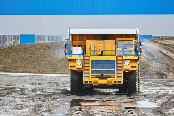 Large quarry dump truck. Big yellow mining truck at work site. Production useful minerals