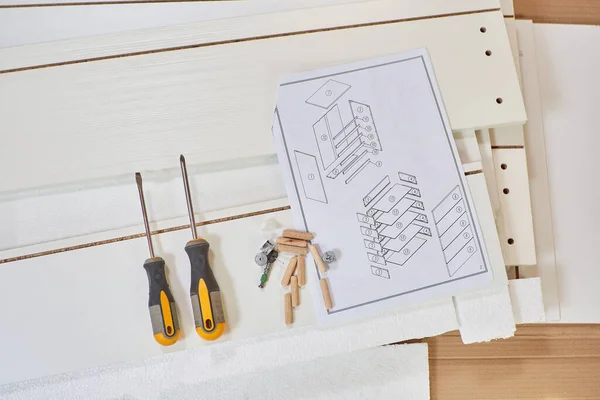 Assembling wooden furniture for the cabinet at home with screwdrivers
